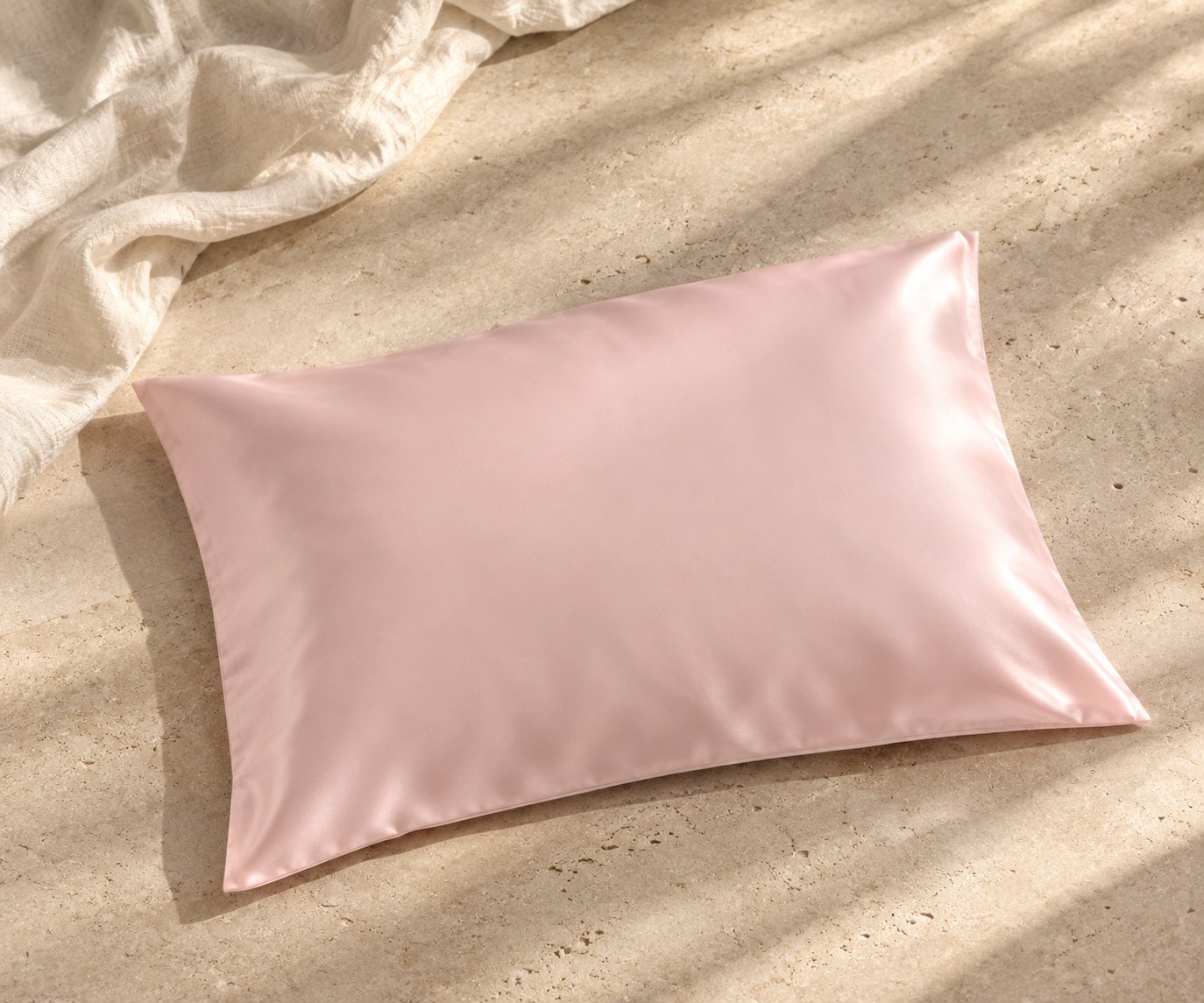 Pink mulberry silk pillowcase on a sunlit stone surface